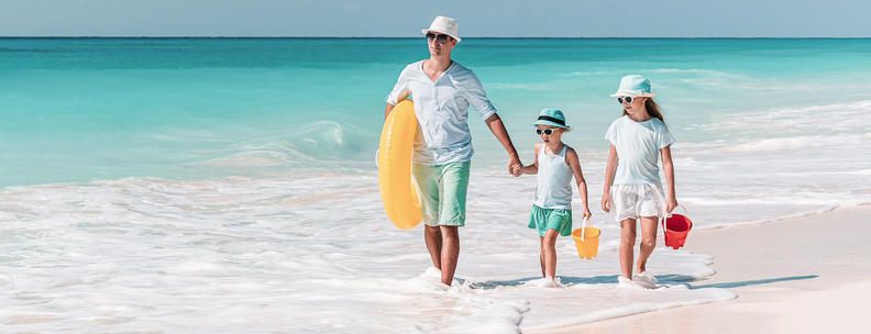 Vater mit Kindern am Strand