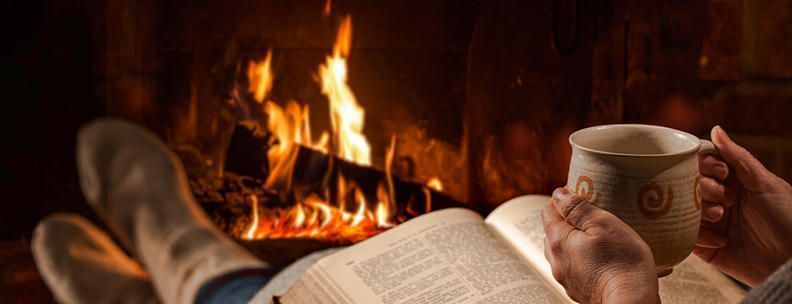 Person vor Kamin Ferienhaus