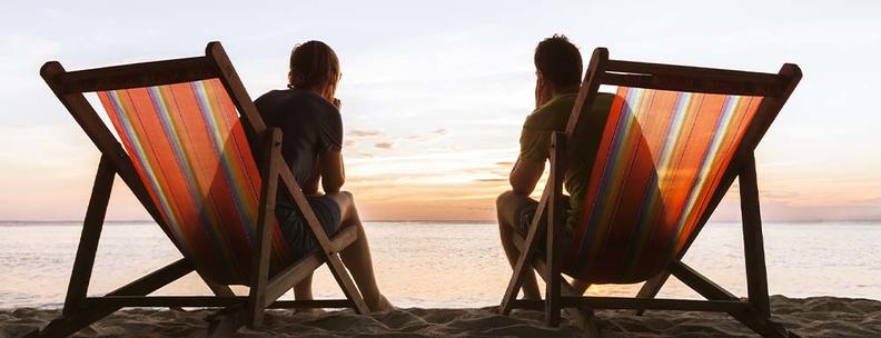 Paar am Strand auf Liegen