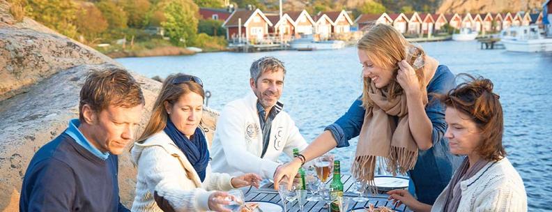 Freunde genißen Mahlzeit in Schweden Ferienhaus 2022