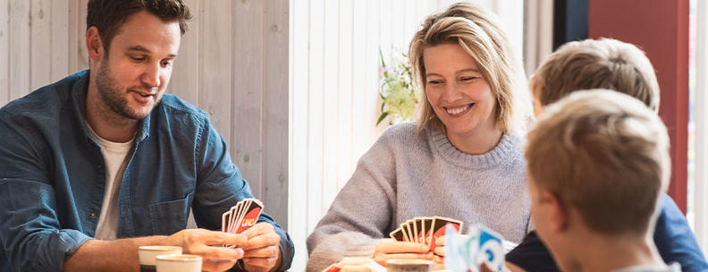 Familie spielt Karten im Ferienhaus